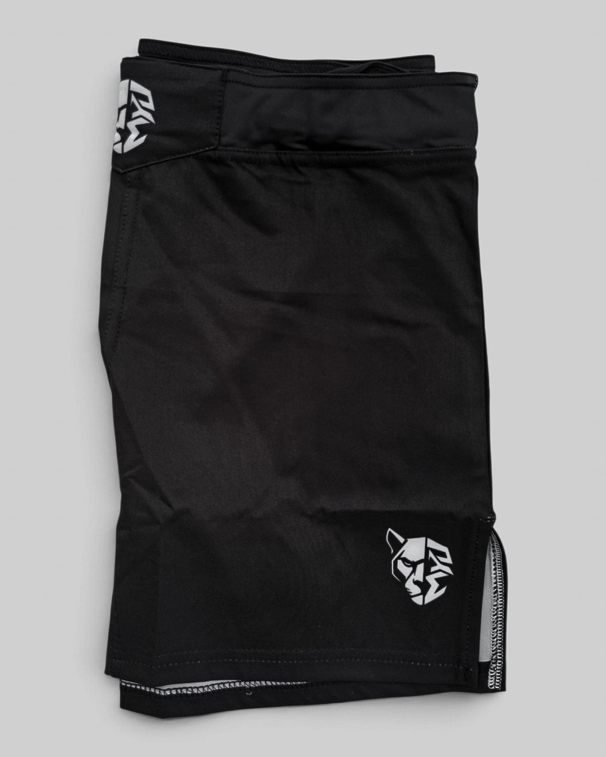 MYU Black fight shorts, plain black grappling and MMA shorts — folded side angle