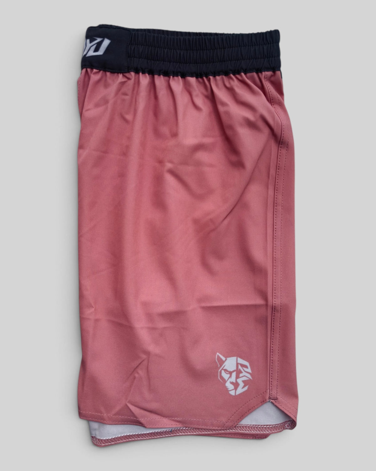 MYU Dusty Rose fight shorts, muted pink grappling and MMA shorts — folded side angle